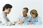 Mature father and two sons playing chess, all smiling