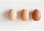 Three eggs against white background, close-up