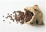 Coffee beans in and spilling out of burlap sack