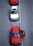 Red and white cars parked on asphalt,  birdseye view.