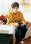 Boy playing video games on couch.