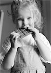 Girl eating chocolate bar, b&w