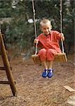 Petit garçon assis sur une balançoire