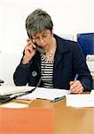 Woman sitting at desk, telephoning