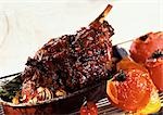 Roasted leg of lamb with tomatoes and herbs, in casserole dish, close-up