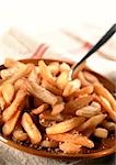 Mound of salted french fries on plate, close-up