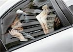 Unternehmer, die sitzen hinter dem Auto holding Zeitungs- und Handy, gesehen durch Fenster