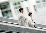 Two businessmen walking down stairs, blurred