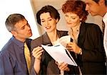 Four business people examining documents