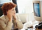 Femme d'affaires à la recherche à l'écran de l'ordinateur, tenant tête