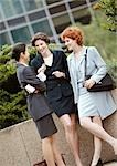 Three businesswomen standing in front of low wall