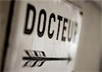 Doctor text in French on sign with arrow, close-up