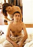 Woman massaging bare-chested man's shoulders