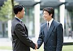Two businessmen shaking hands, outdoors