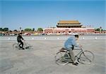 Chine, Beijing, deux personnes circonscription vélos dans la rue en face de la cité interdite