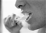 Person brushing teeth, close-up, b&w