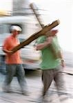 Israel, Jerusalem, two men carrying wooden cross, blurred