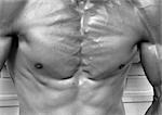 Man's flexed chest muscles, b&w