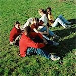 Young people sitting on grass, high angle view