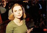 Young woman in bar looking at camera, portrait.