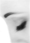 Woman's closed eye, close-up, black and white, blurry.