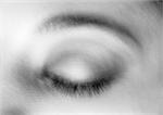 Woman's closed eye, close-up, blurry, black and white.