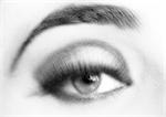 Woman's made-up eye, close-up, blurry, black and white.