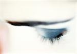 Woman's closed eye with blue eye shadow, close-up, high angle view, blurry.