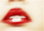 Woman wearing red lipstick, close up of mouth, blurred.