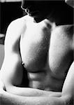 Torse homme traversant le bras, close-up, noir et blanc.