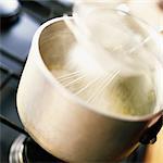 Close-up of bechamel sauce being prepared in pot on stove