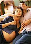 Femme enceinte et l'homme endormi sur le canapé