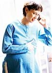 La femme enceinte à l'aide d'un téléphone cellulaire, portrait