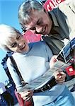 Mature woman and man examining a brochure, close-up