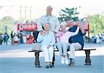 Group of mature people on a bench, smiling at camera, portrait