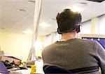 Mann tragen von Kopfhörern und sitzen am Computer, Rückansicht