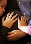 Enfants toucher le ventre enceinte de mère, gros plan