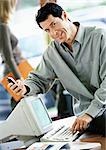 Businessman sitting on desk with cell phone