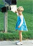 Girl standing in front of mailbox, looking into camera