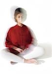 Woman sitting indian style, meditating, blurred
