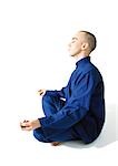 Man sitting in lotus position, meditating, side view