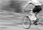 Man cycling, side view, blurred, b&w.