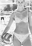 Jeune femme souriante sur plage, holding de volley-ball, portrait, b&w.