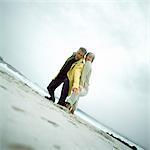 Mature couple on beach looking down into camera