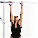 Young female gymnast gripping horizontal bar