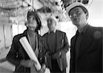 Two men and woman wearing hard hats, blurred, b&w
