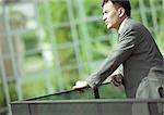 Businessman leaning on railing, close-up
