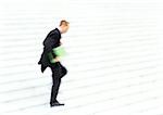 Businessman running down steps, side view, blurred motion