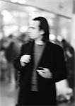 Businessman holding cell phone, blurred, b&w