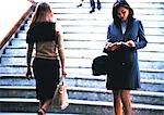 Businesswoman taking notes in front of stairs